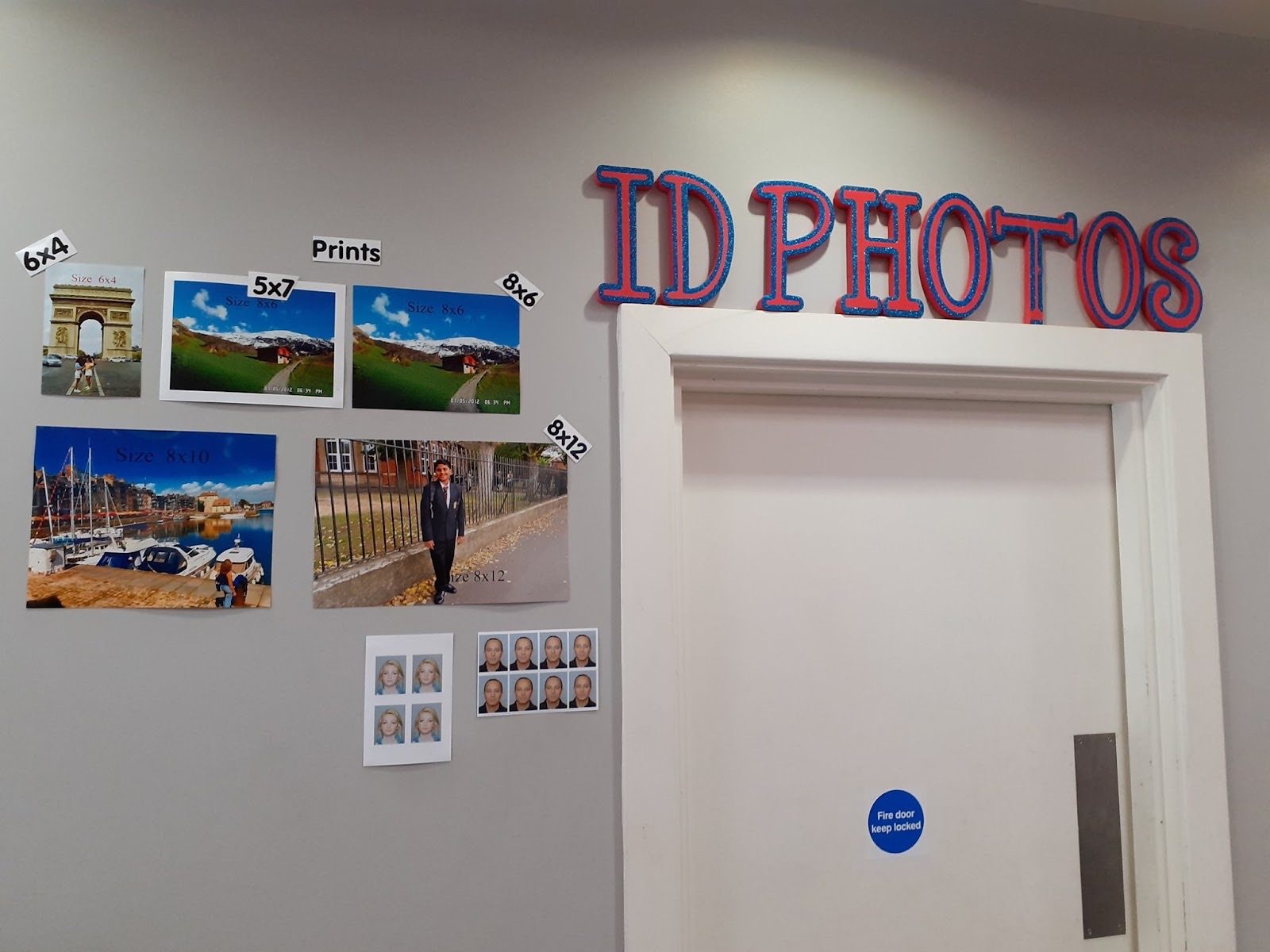 The ID photo wall by the doorway inside 119 Wandsworth High Street.