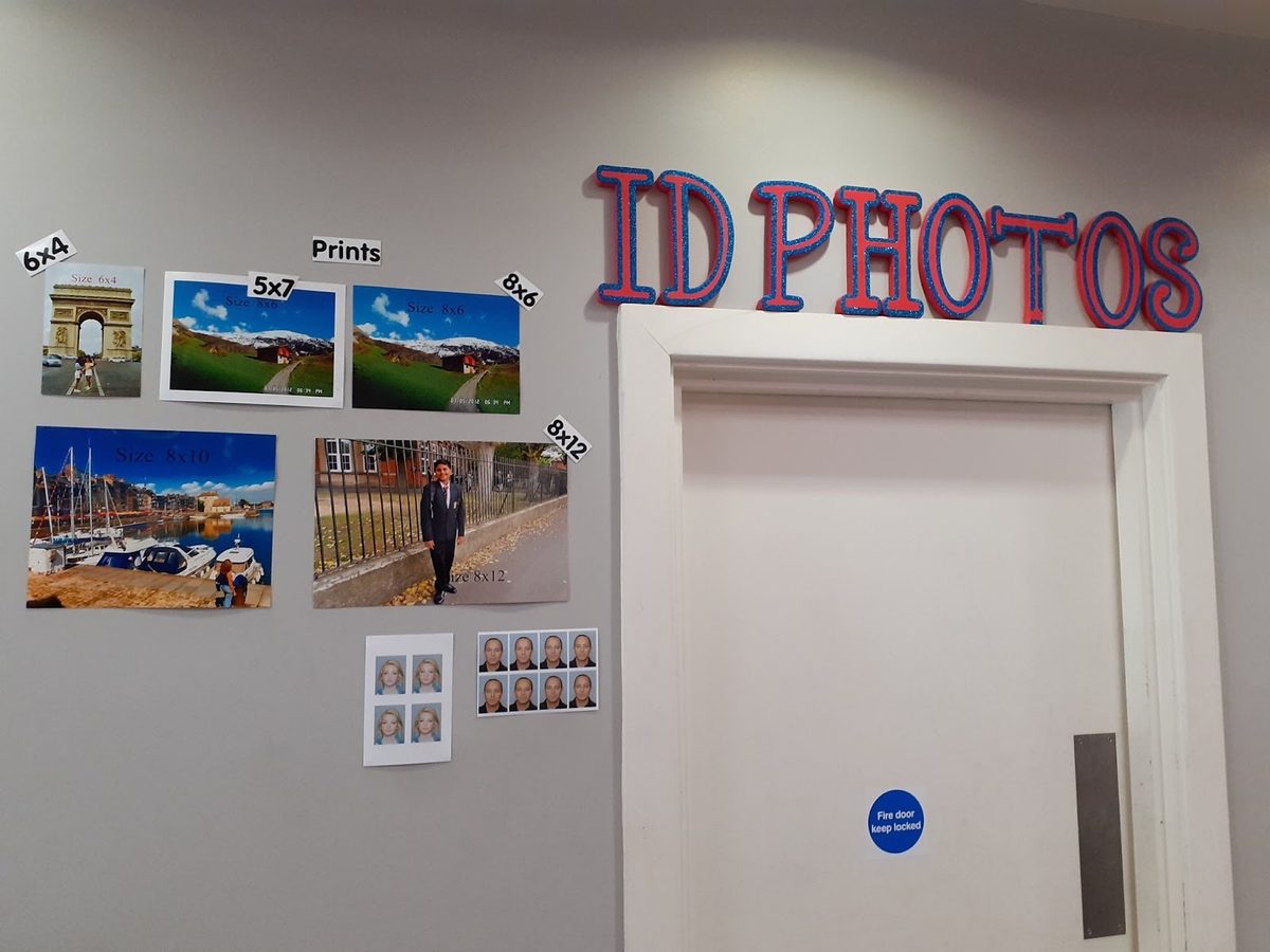 Inside the shop on Wandsworth High Street: the ID photo wall beside the doorway, hung with sample passport and visa photo sheets.